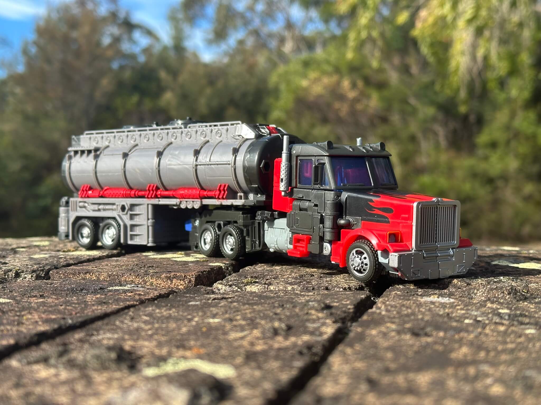 Semi trailer tanker Transformer with trees blurred in the background