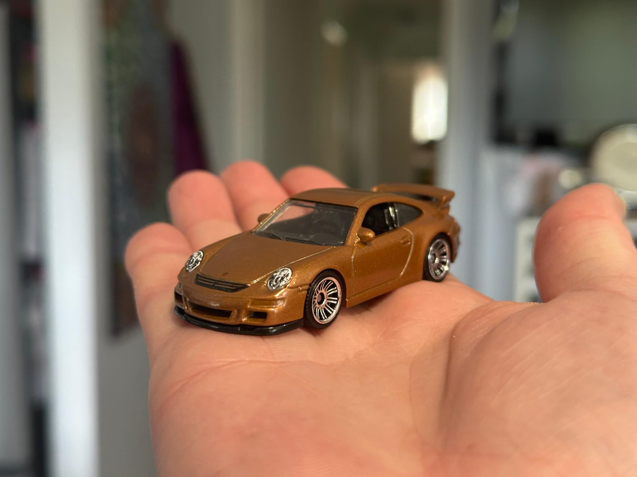 Close up of brown Hot Wheels car sitting on an outstretched palm