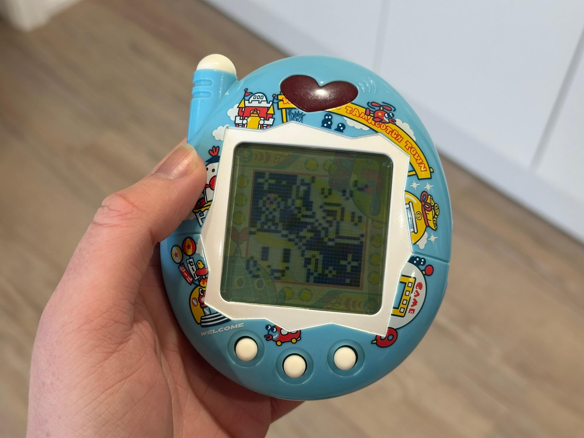 Large blue Tamagotchi held in hand