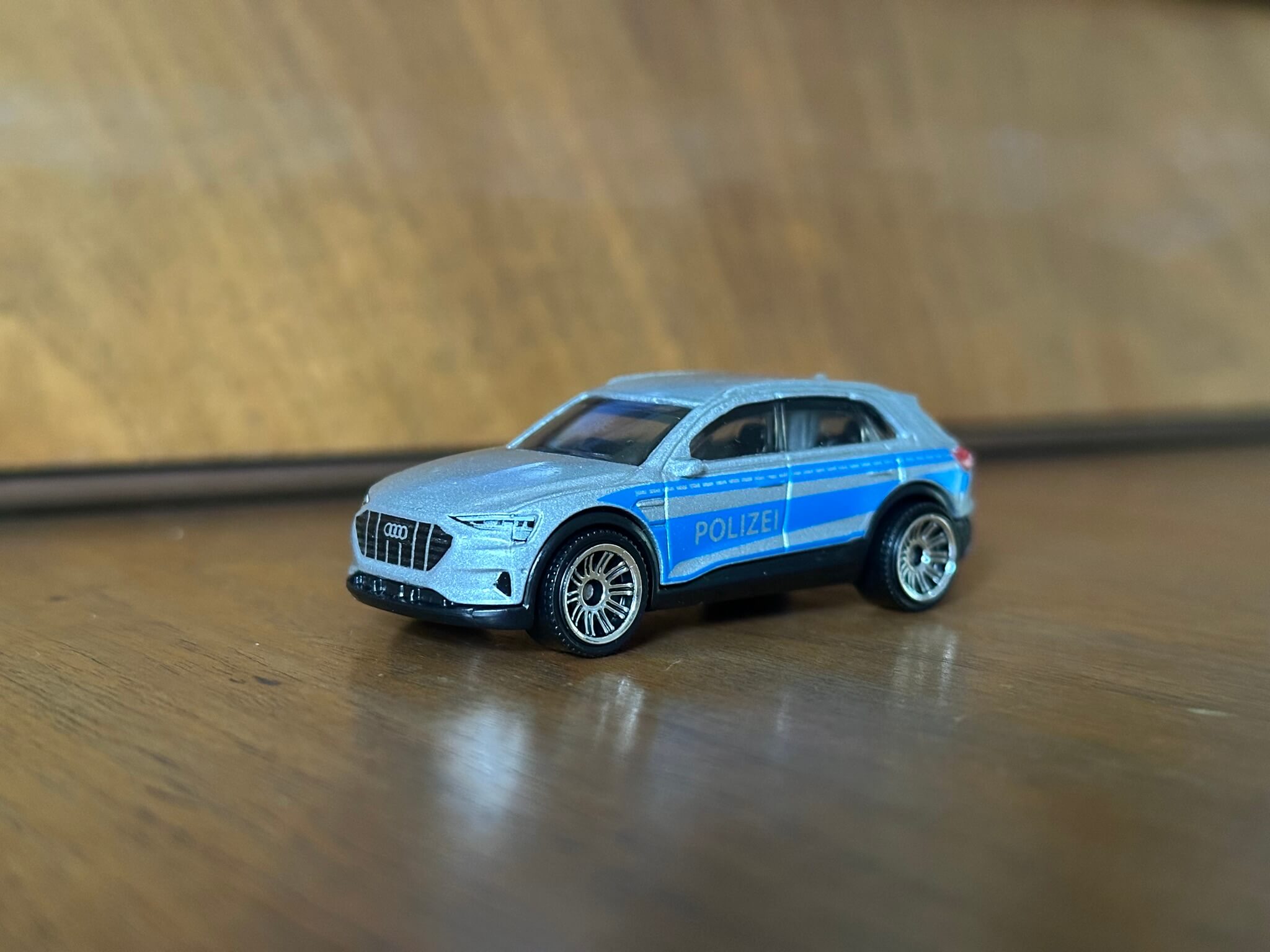 Close up of silver toy car on wooden surface