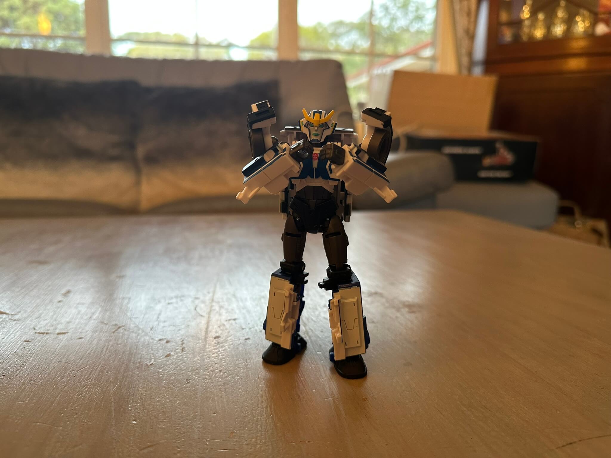 Transformer standing on table with arms held up