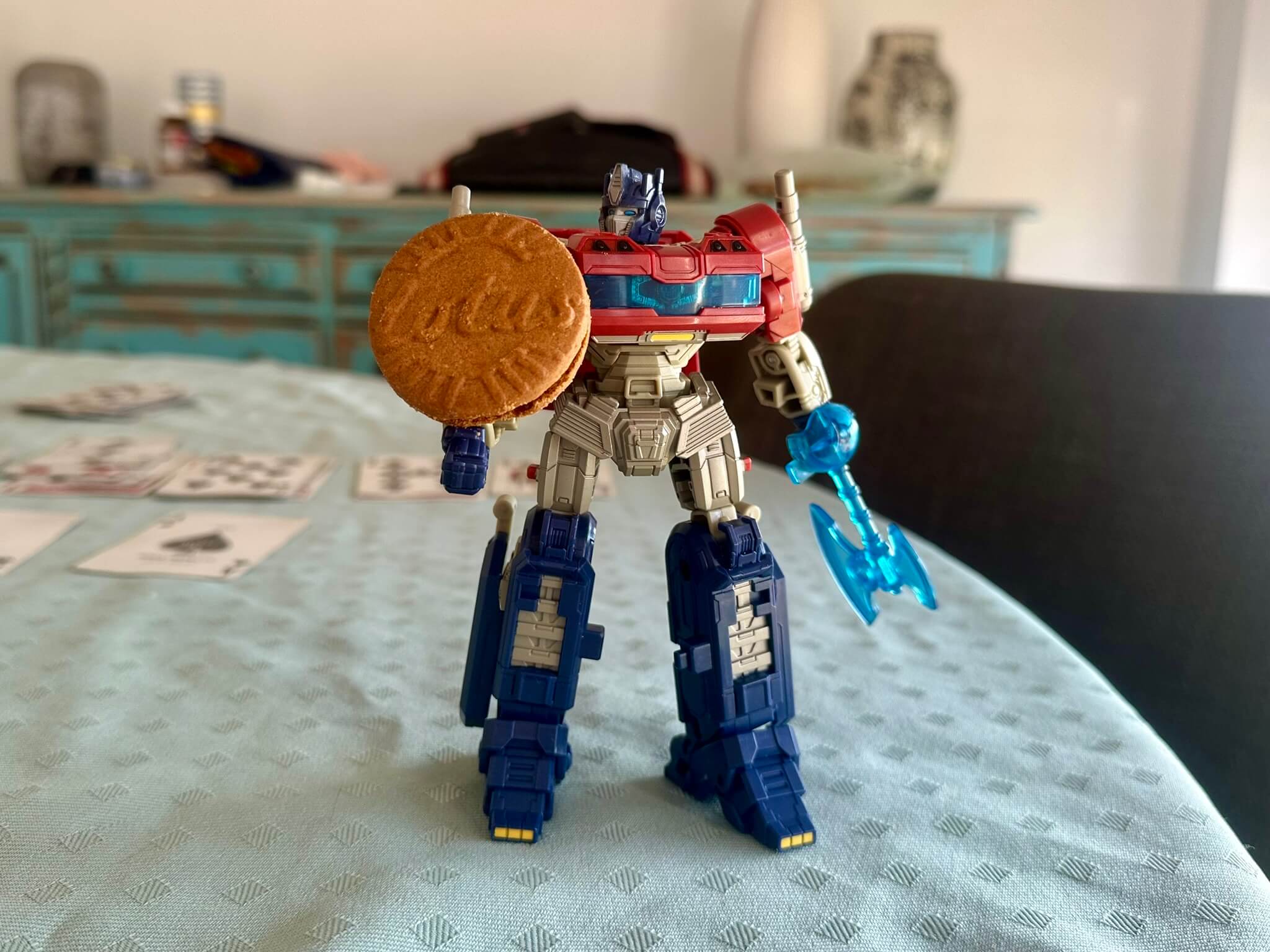 Optimus Prime Transformer standing on table holding a biscuit